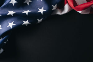 A folded American flag against a black background.